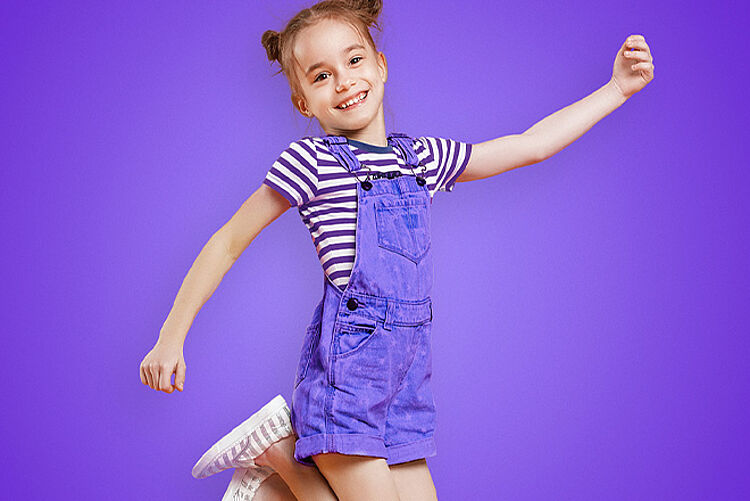 KiTa_lila KiTa - Ein Mädchen springt in die Luft und freut sich auf die KiTa