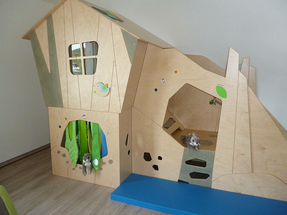 Rothemühler Knripse_Kletterlandschaft Kletterlandschaft gestaltet wie ein Haus mit Tür und Fenster. Davor liegt eine Matte