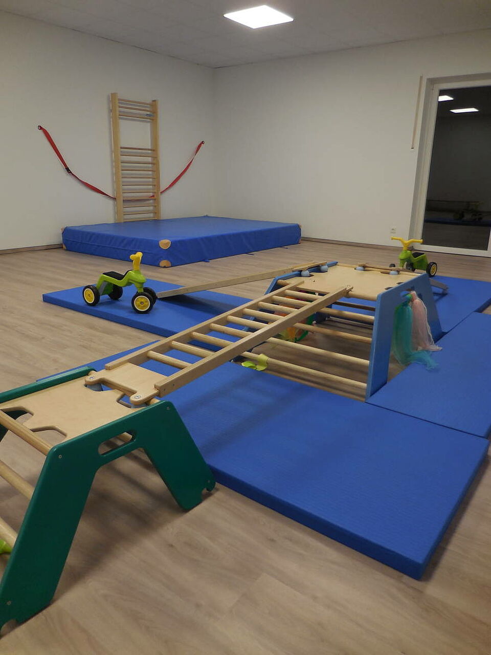 Rothemühler Knirpse_Turnraum Turnraum mit Kletterwand, Matten und Fahrzeugen