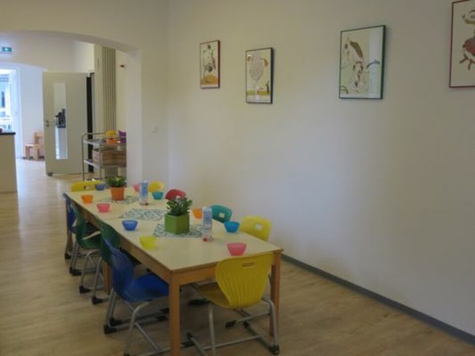 FLohkiste_Kindergarten_Bistro Bistro mit langer, gedeckter Tafel und Stühlen für das Mittagessen der Kinder