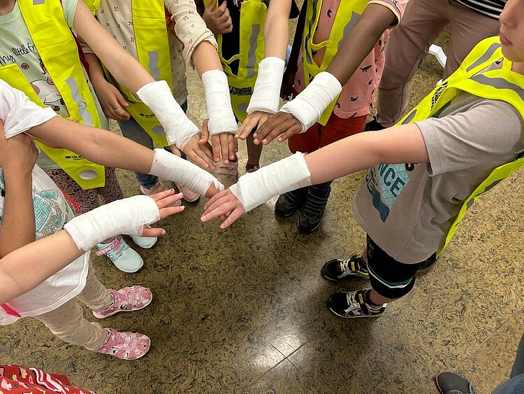 Sternenland_Notaufnahme-01_2025-06 Kinder halten ihren Arm mit Verband in die Mitte