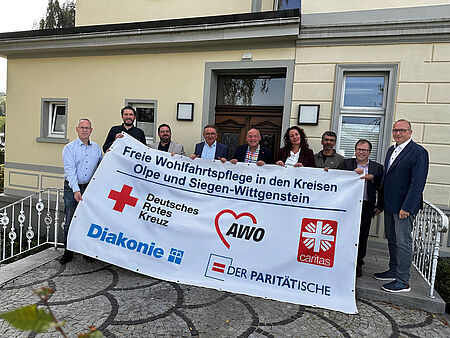 Arbeitsgemeinschaft Freie Wohlfahrtspflege Olpe und Siegen-Wittgenstein Vertreterinnen und Vertreter der Arbeitsgemeinschaft der Freien Wohlfahrtspflege aus den Kreisen Olpe und Siegen-Wittgenstein stehen hinter einem Banner